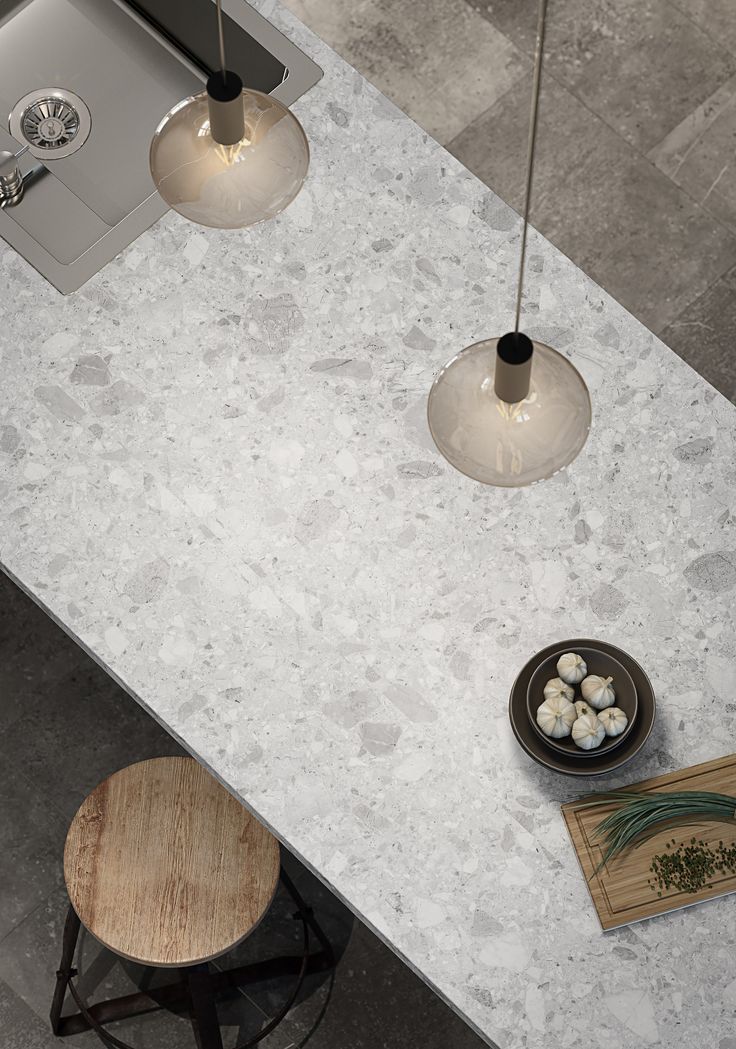 an overhead view of a kitchen counter top with two lights hanging over it and a bowl of food on the counter