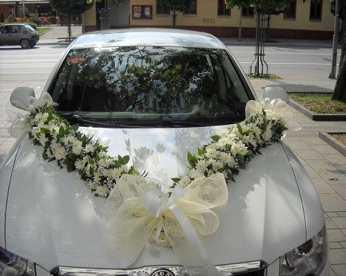 a white car decorated with flowers and ribbons