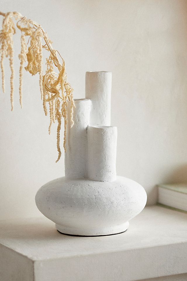 a white vase sitting on top of a shelf