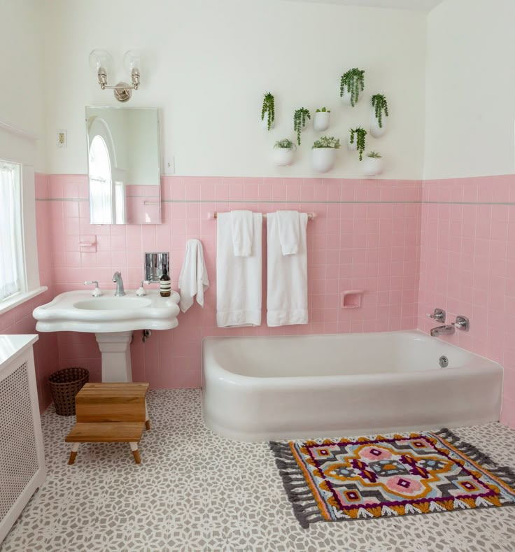 a bathroom with pink and white walls, flooring and rugs