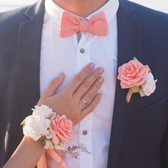 a close up of two people wearing boutonnieres with flowers on their lapels