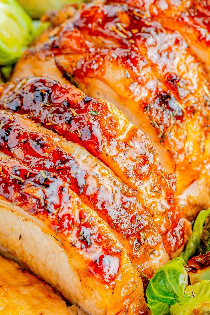 a close up of meat with sauce on it and lettuce in the background