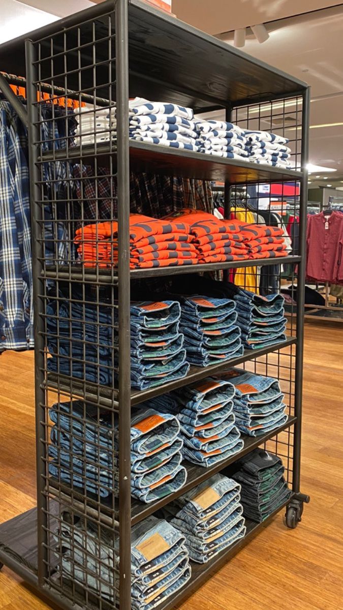 a metal rack filled with lots of blue and orange plates on top of wooden floors