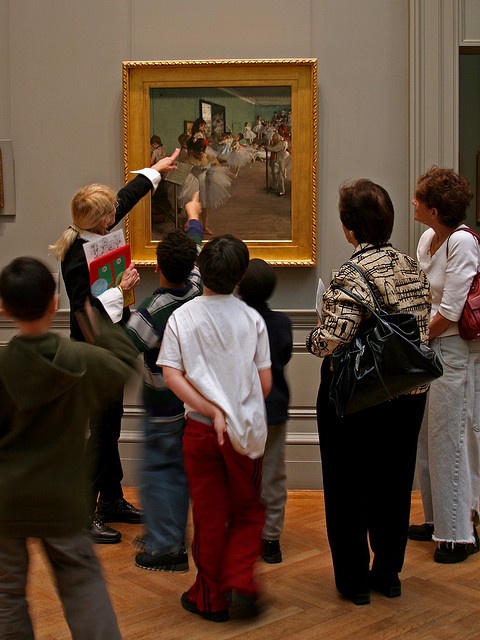 a group of children standing in front of a painting