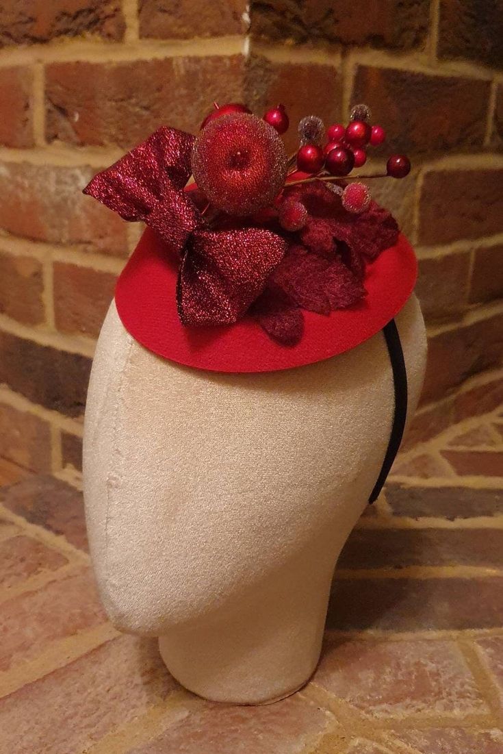 Little Hats for Grand Occasions. Glittery red bow and berry design christmas pillbox fascinator. Perfect for the festive season and  christmas weddings. Embellishments, feathers, buttons and brooches are lovingly sourced for unique individual pieces. Hats are 16cm by 13.5cm and dispatched in a box. 2 clips and a headband are provided for ease of fixing in place.  Handmade in the UK. No two designs are the same. Please message me to discuss any personal requirements. Return and exchanges except within 14 days. Please read the full details in the FAQS. Many more designs on the shop. Christmas Fascinator, Pillbox Fascinator, Berry Cocktail, Company Christmas Party, Tea Hats, Christmas Weddings, Holiday Hats, Christmas Glitter, Wedding Fascinators