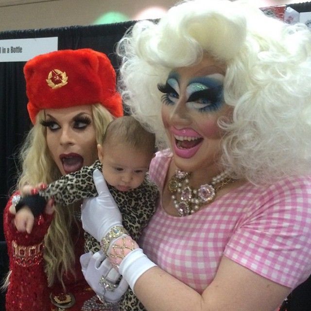 two women and a baby are dressed up as drag queen and clowns for halloween