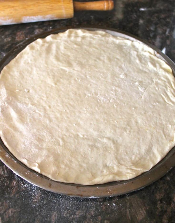 an uncooked pizza dough sitting on top of a counter