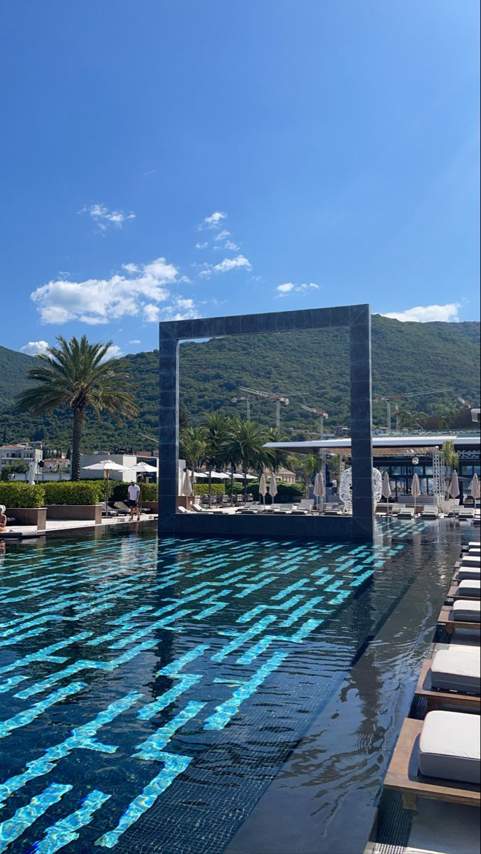 an empty swimming pool with lounge chairs around it