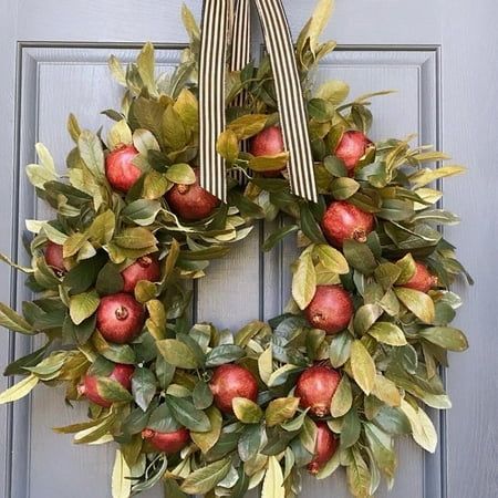 an apple wreath is hanging on the front door