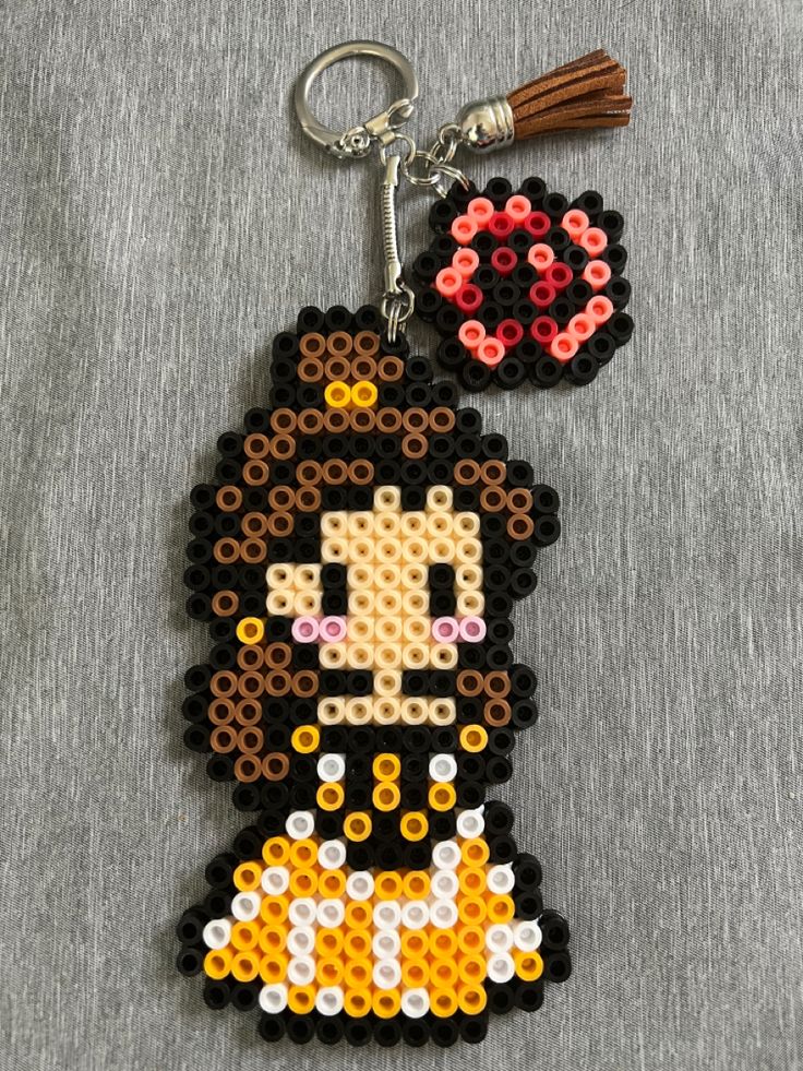 a keychain made out of legos and beads with a cartoon character on it