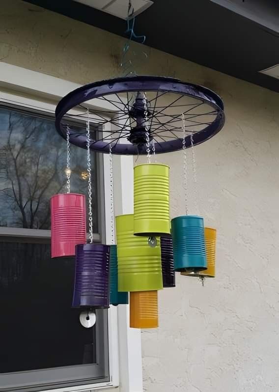 a wind chime hanging from the side of a building with paper lanterns attached to it