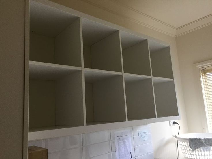 an empty kitchen with white cupboards and tile backsplashes on the wall