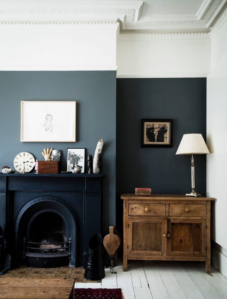 a living room with a fireplace and pictures on the wall next to an old dresser