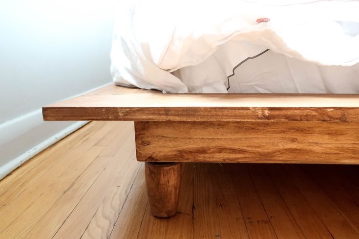 a wooden bench sitting on top of a hard wood floor