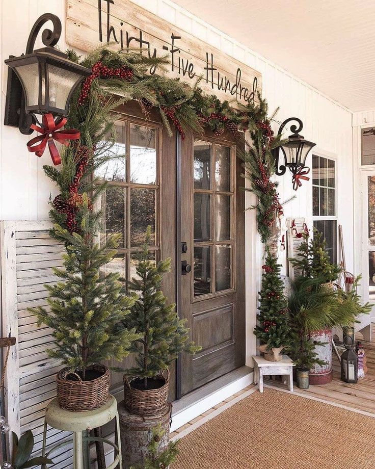 christmas decorations on the front door of a house with wreaths and pine trees in baskets