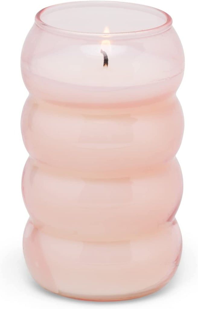 a pink glass candle holder sitting on top of a table