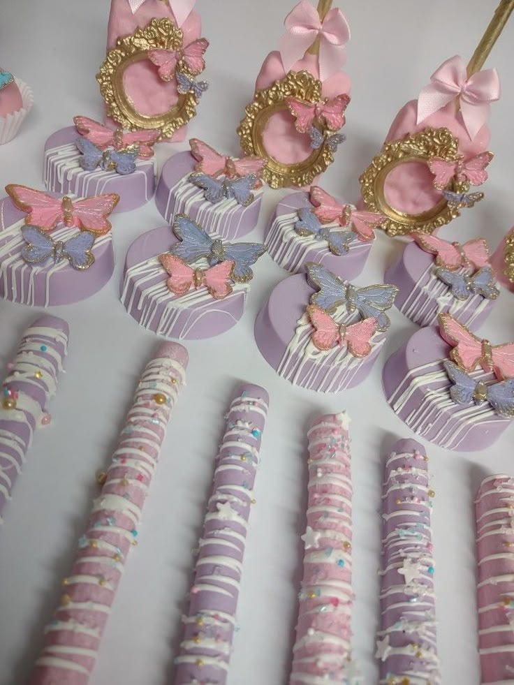 a table topped with lots of pink and purple cupcakes