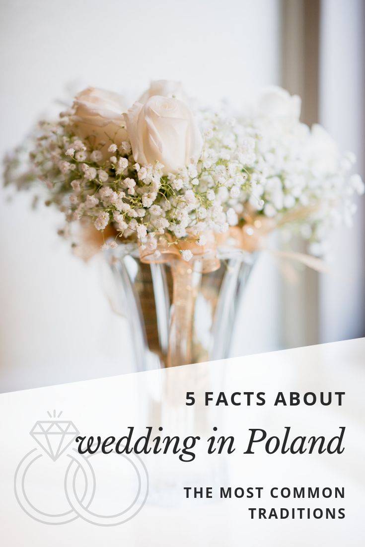 a vase filled with white flowers and baby's breath on top of a table