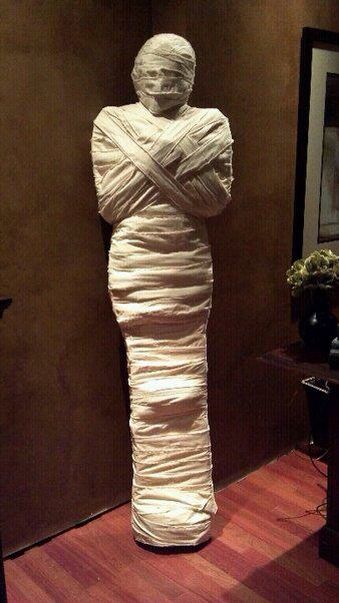 a statue is wrapped in white paper on the floor