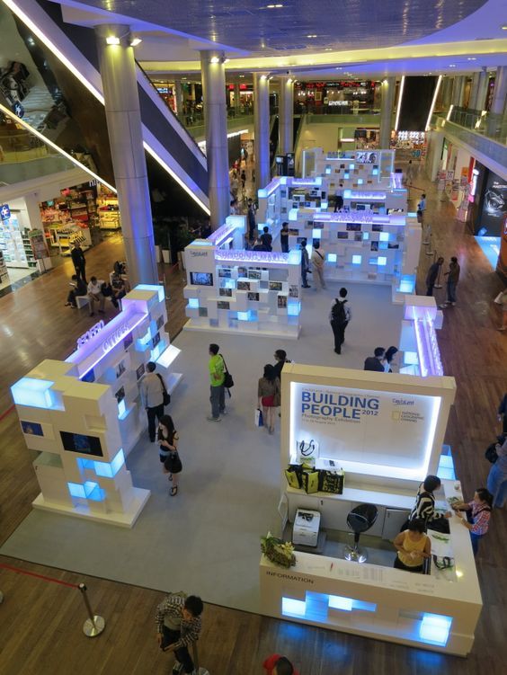 an overhead view of people walking around in a shopping mall with blue lights on the ceiling