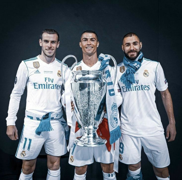 two men standing next to each other in front of a trophy