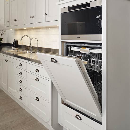 an open dishwasher in the middle of a kitchen with white cabinets and drawers