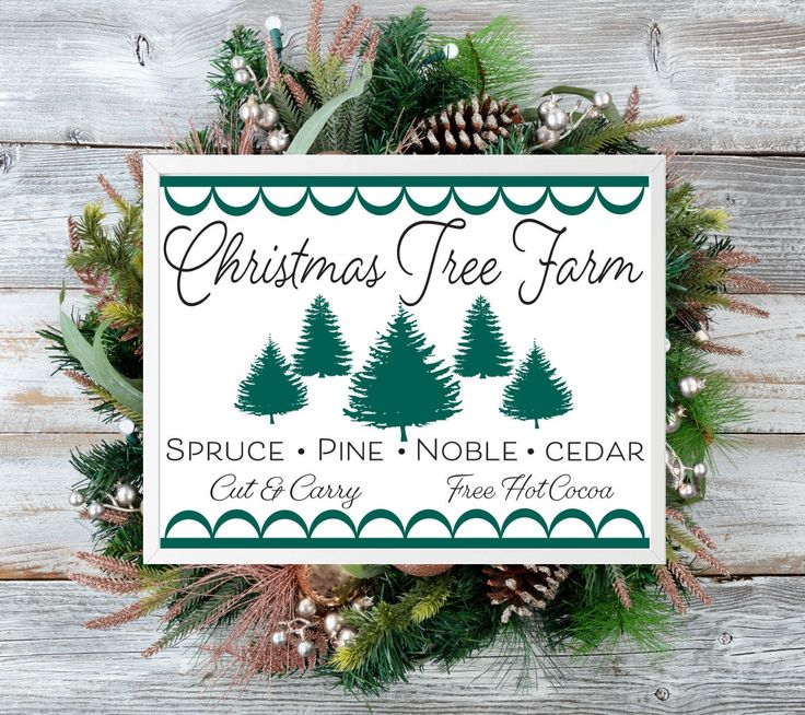 a christmas tree farm sign with pine cones and evergreens around it on a wooden background