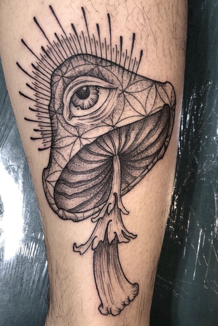 a black and white tattoo with an all seeing eye on the side of someone's leg