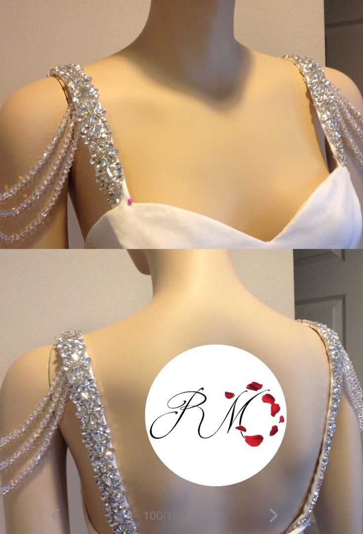 the back of a wedding dress with beading on it and an embroidered monogram