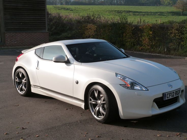 a white sports car parked in a parking lot