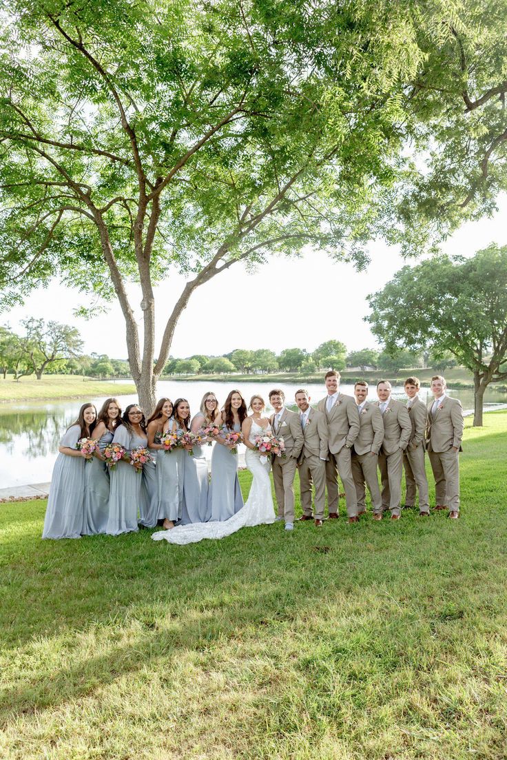 a group of people standing next to each other in front of a tree