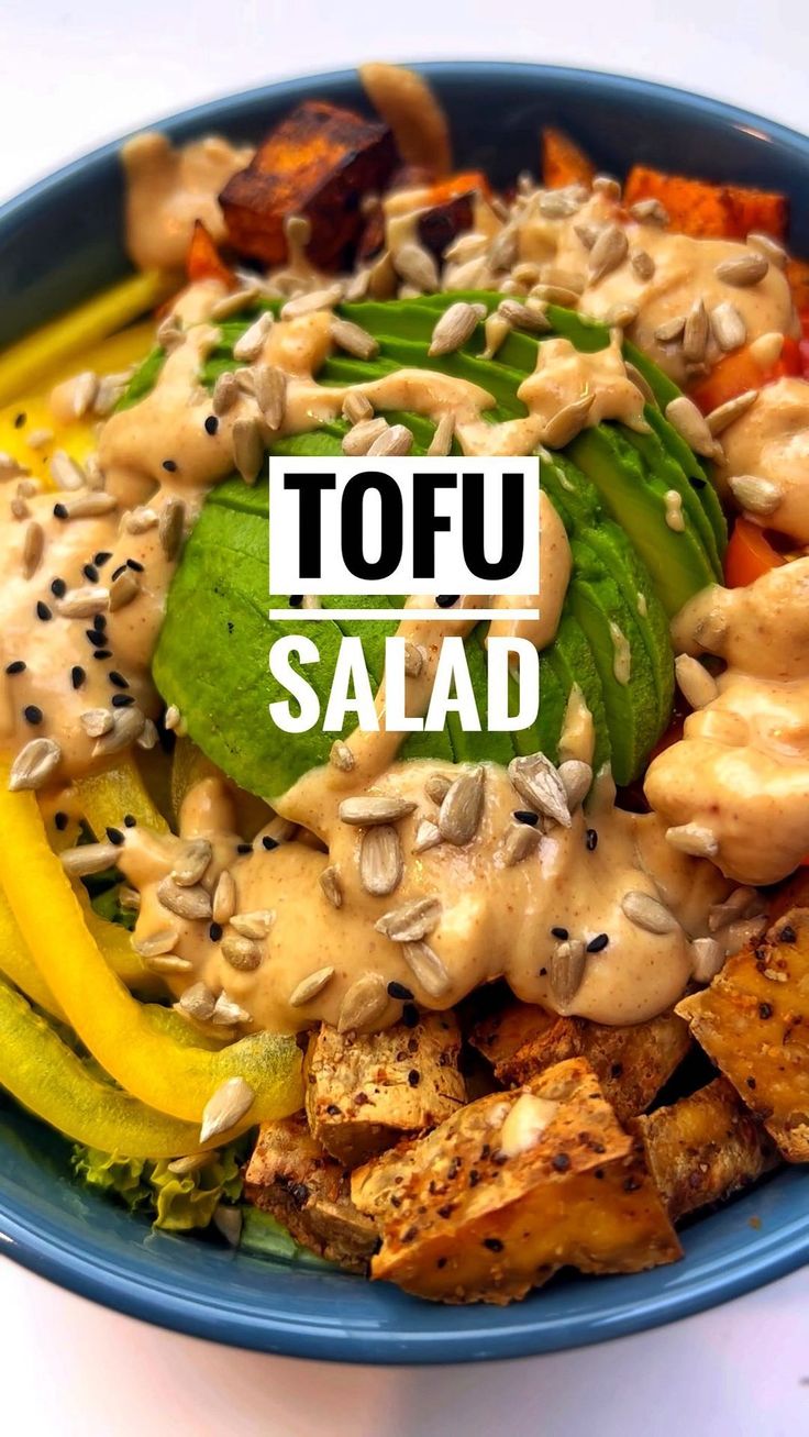 a blue bowl filled with different types of food and the words tofu salad above it