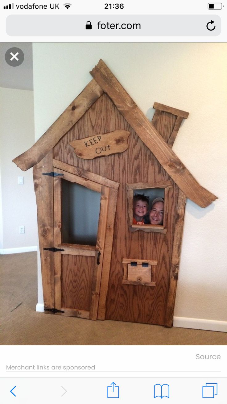 two people in a wooden house made out of pallet boards with the words keep out on it