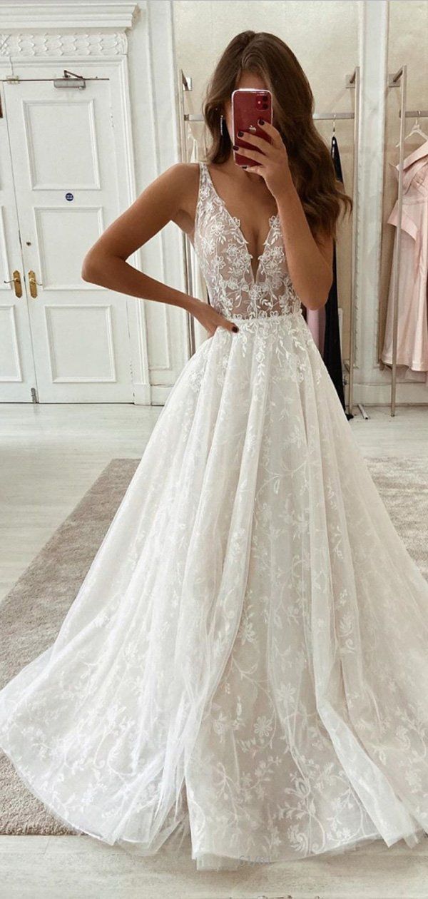 a woman taking a selfie while wearing a wedding dress in front of a mirror