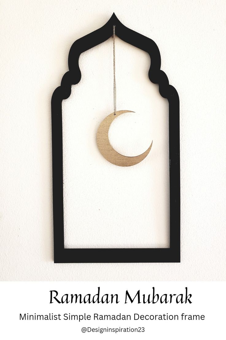 a black frame with a wooden crescent hanging from it's side on a white wall