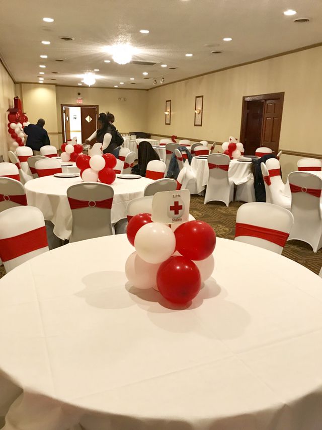 tables with white and red tablecloths are decorated for an event