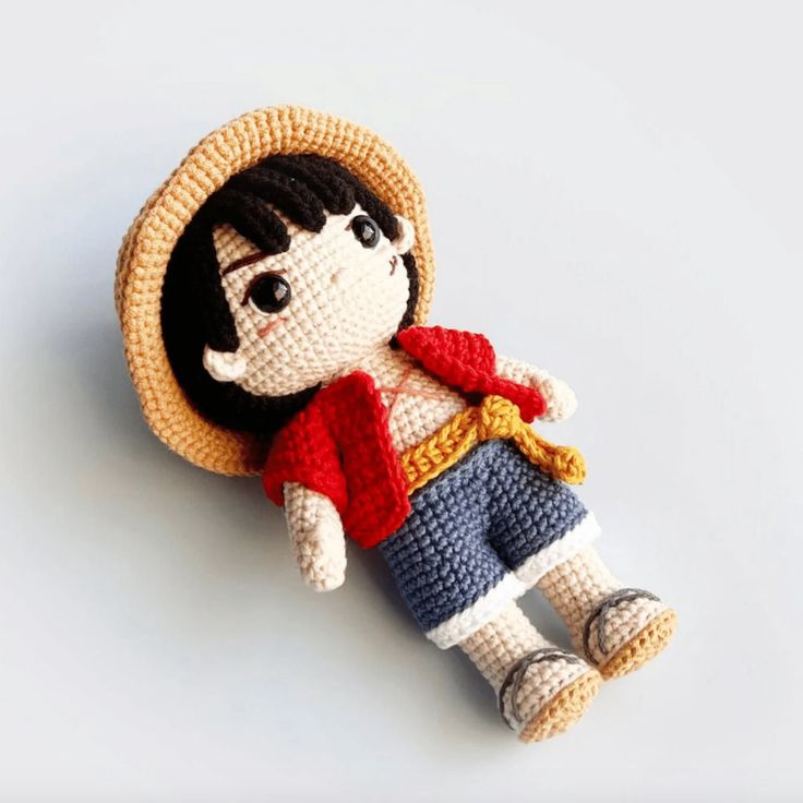 a crocheted doll with a straw hat on it's head is laying down