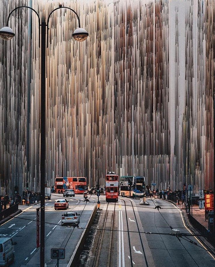 the city street is lined with tall buildings and traffic lights on either side of it