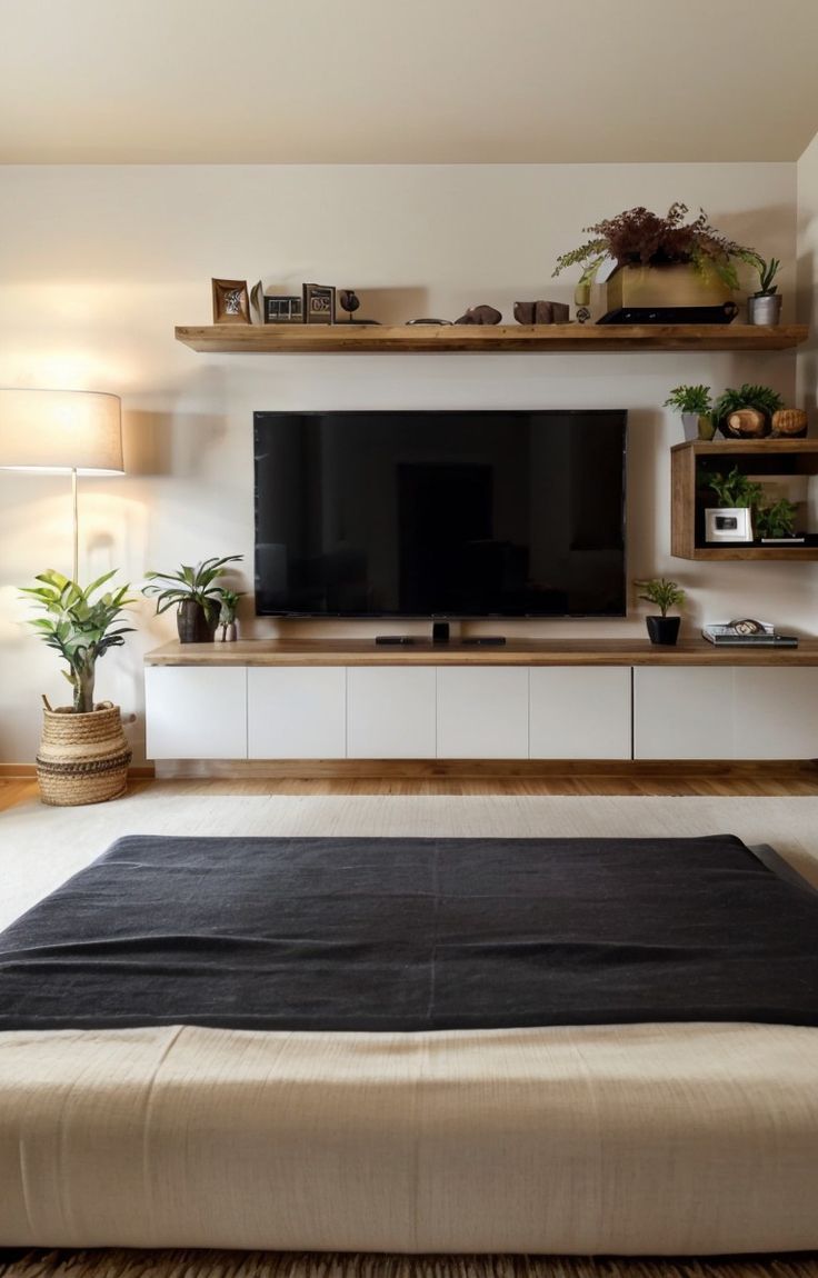 a large flat screen tv sitting on top of a wooden shelf in a living room