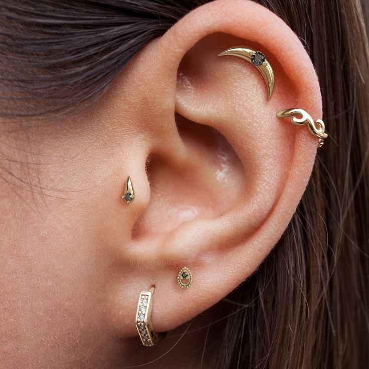 a woman wearing three different ear piercings