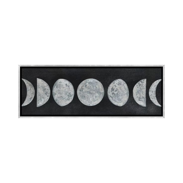 four phases of the moon on a black and white background, framed in a wooden frame