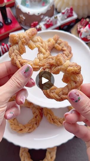 two hands holding up some food on a plate