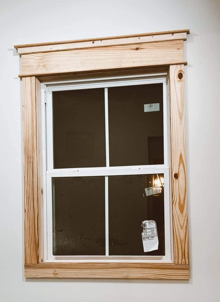 an empty window in a white room with wood trimming on the outside and inside