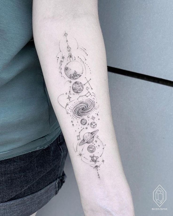 a woman with a tattoo on her arm that has planets and stars in the sky