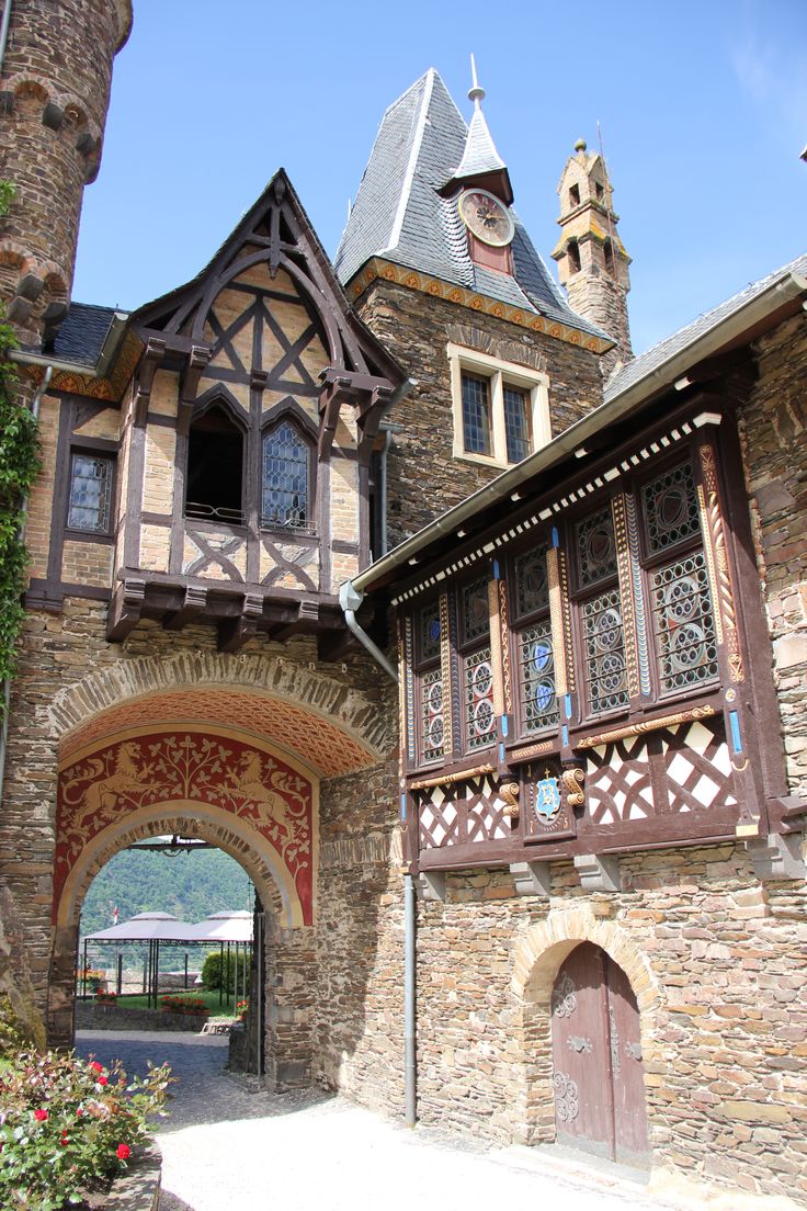 an old stone building with a clock tower on it's side and arched doorway