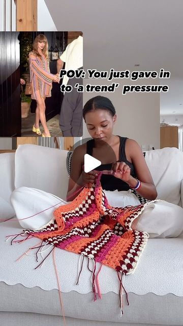 a woman sitting on top of a white couch holding a cell phone next to a crocheted blanket