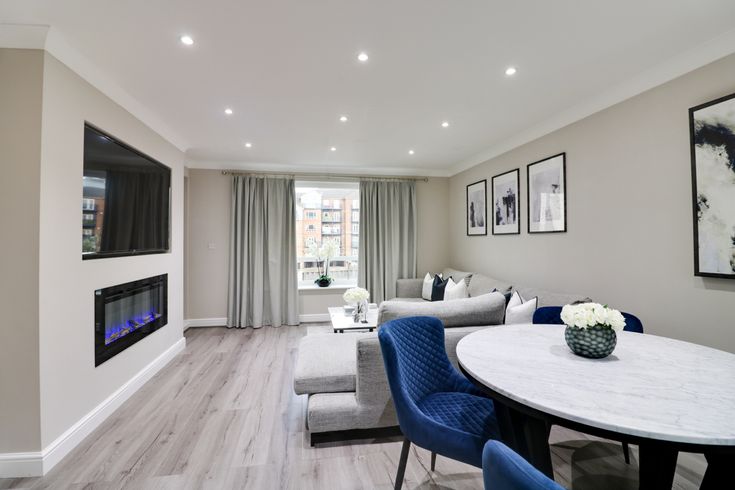 a living room filled with furniture and a flat screen tv mounted to the wall next to a fire place