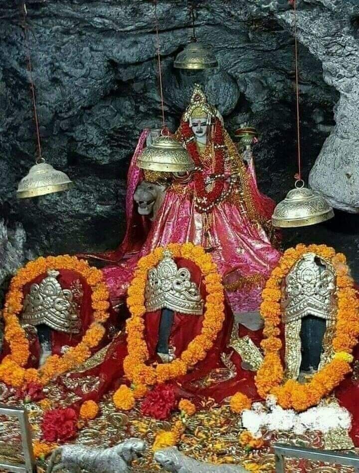 the statue is decorated with orange flowers and garlands in front of it, surrounded by bells