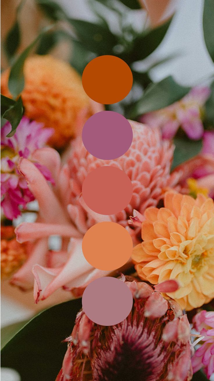 an arrangement of flowers with orange and pink colors