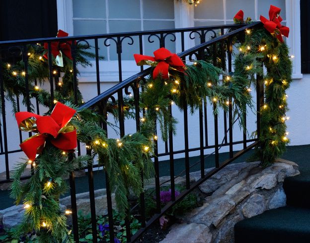 christmas garland and lights on the railing of a house